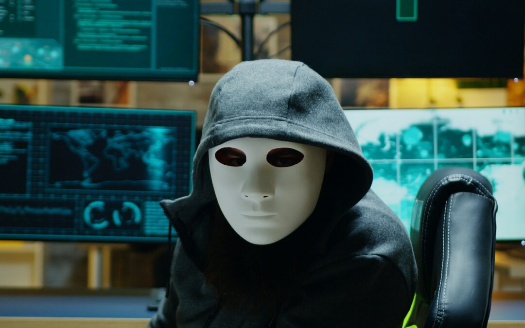 Masked hacker in his apartment looking into the camera