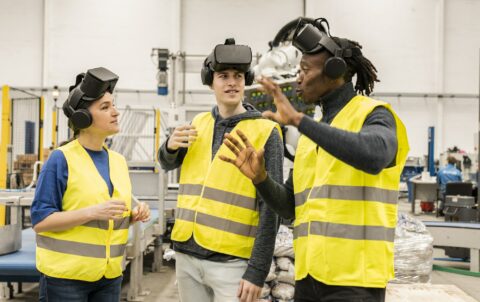multiracial engineers in factory in simulation with virtual reality glasses - metaverse concept -