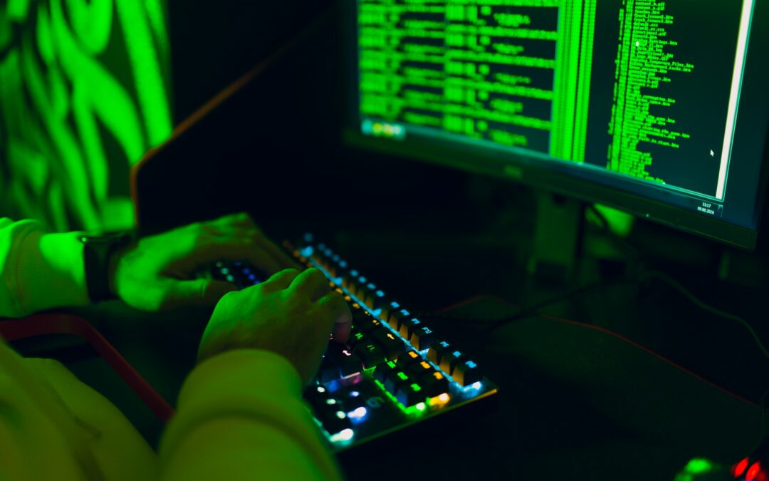 Hacker in hoodie working hacks code site on personal computer with green light